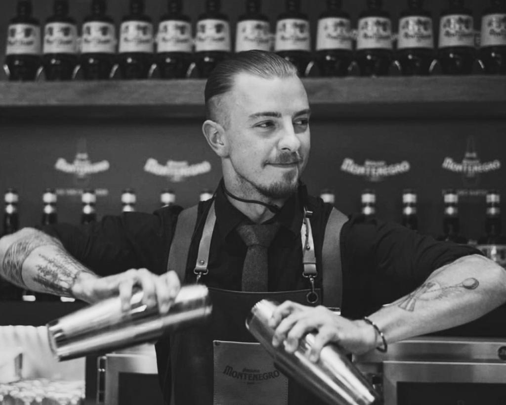 Barkeeper mit Shaker hinter dem Tresen