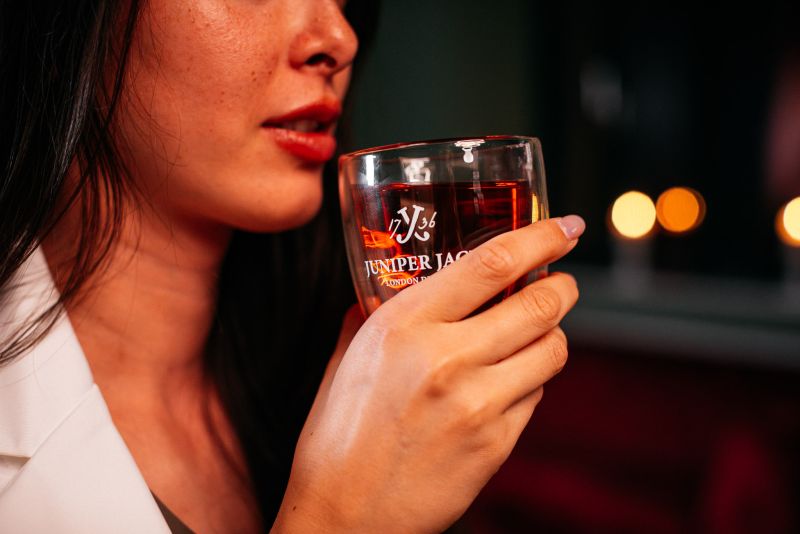 Frau genießt GLÜH Gin-Punsch aus dem Thermoglas