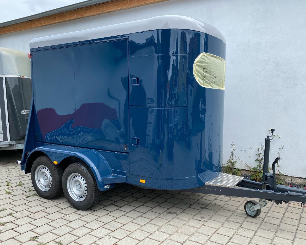 Blauer Anhänger vor der Werkstatt