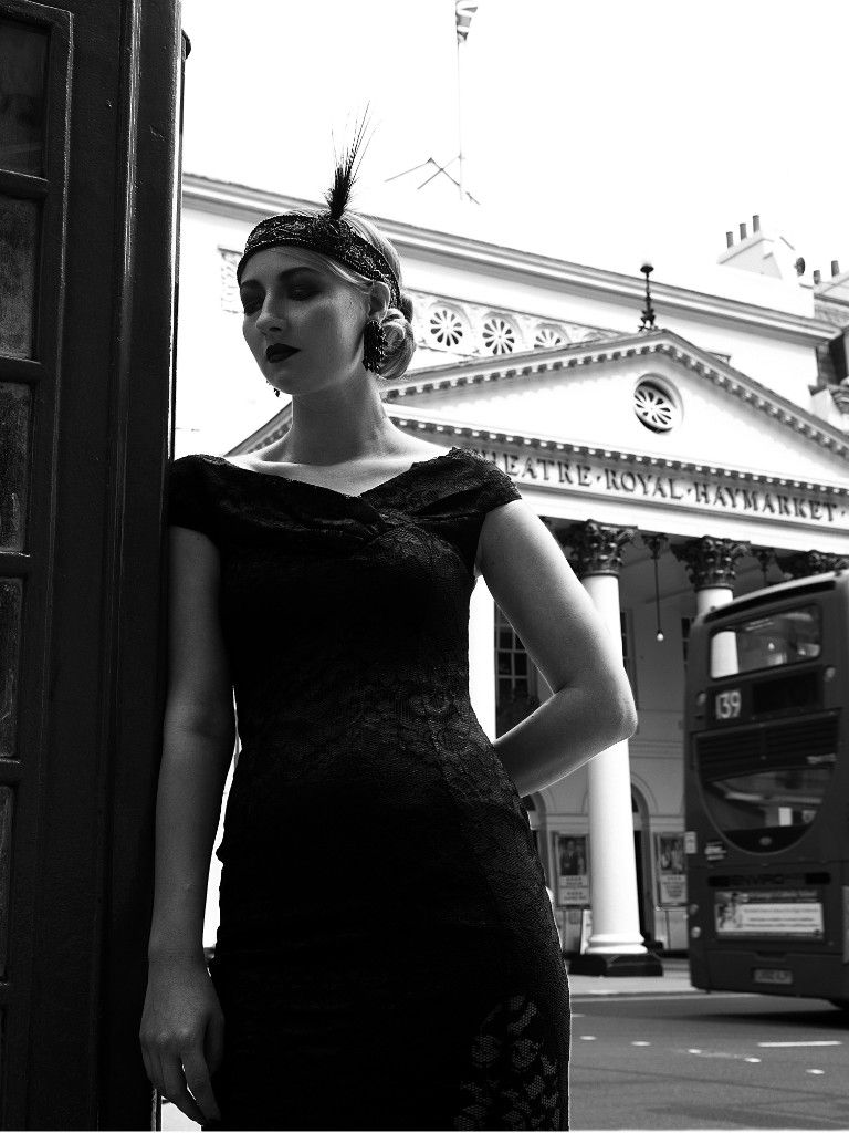 Frau im Kleid der 1920er vor dem Theatre Royal Haymarket in London